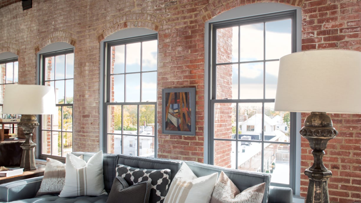 Interior of a loft featuring Andersen E-Series Double-Hung Windows with Colonial Grilles.