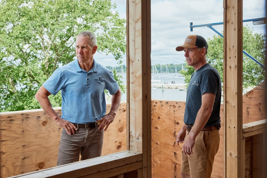 Two pros on a job site looking over the project