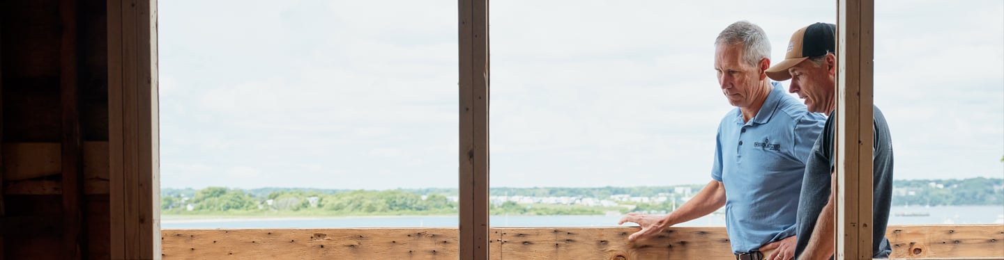 Two pros on a job site looking over the project