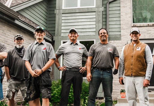 Professionals posing in front of home