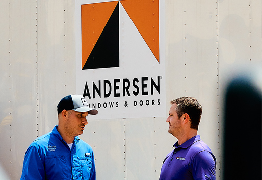 Two men chatting in front of an Andersen Windows truck