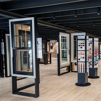 Andersen Windows showroom displaying various products such as double-hung window in black and white and color swatch displays