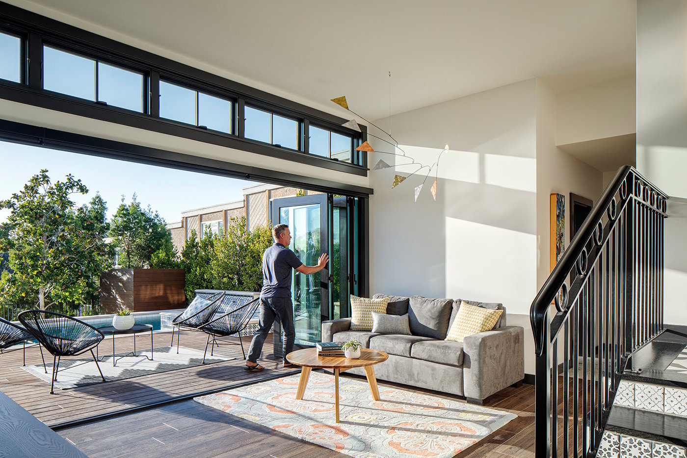 A living room that effectively doubles in space connecting with a deck and hot tub when the Andersen® Folding Outswing Door is open.