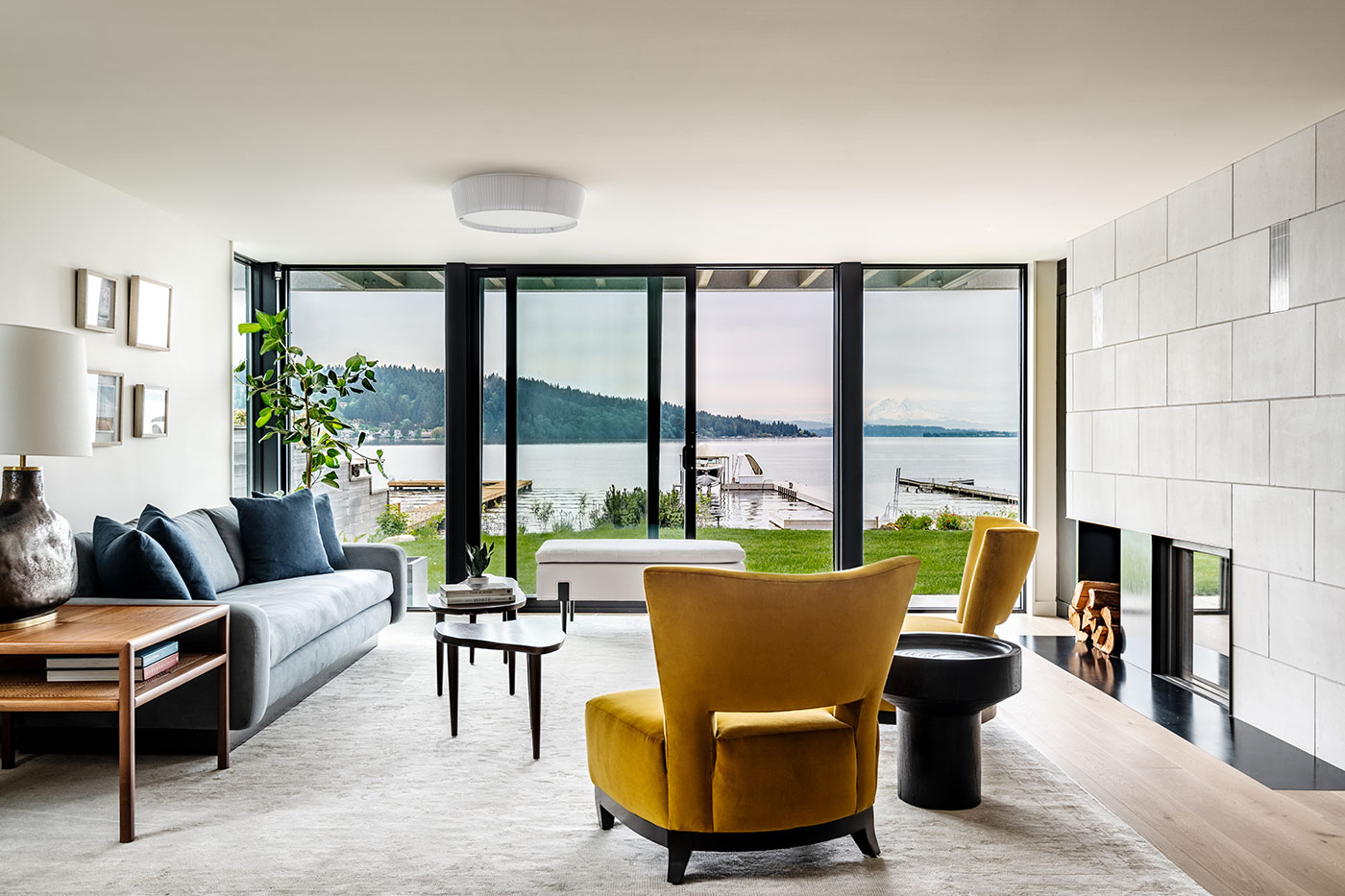 An interior shot of a living room with a view of a large lake through a black E-Series Gliding Patio Door.