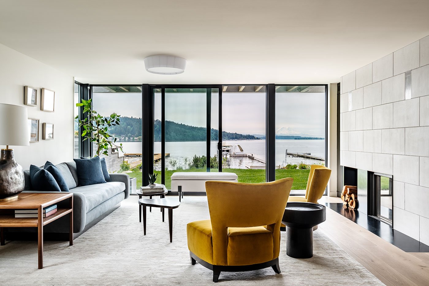An interior shot of a living room with a view of a large lake through a black E-Series Gliding Patio Door.
