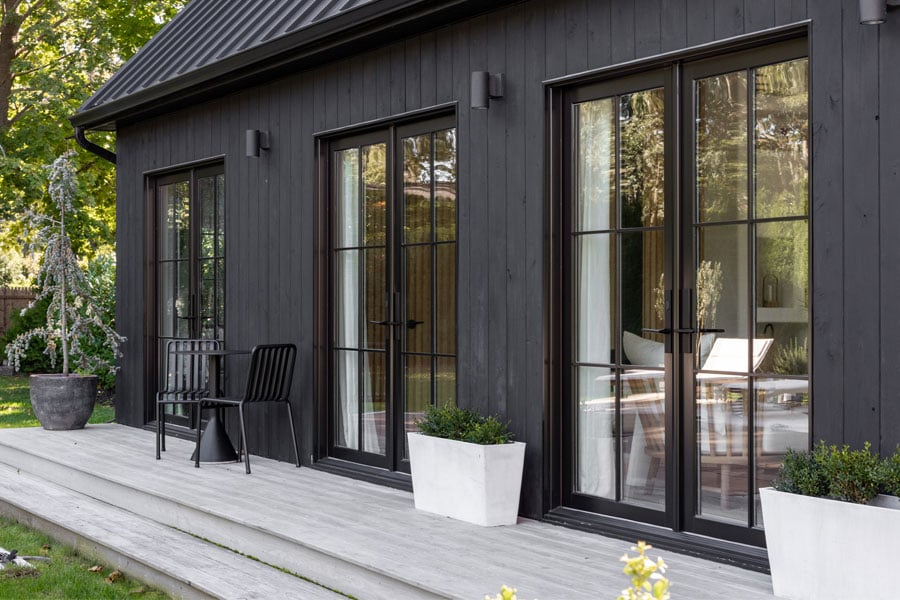 exterior view of black house with andersen black framed windows and door