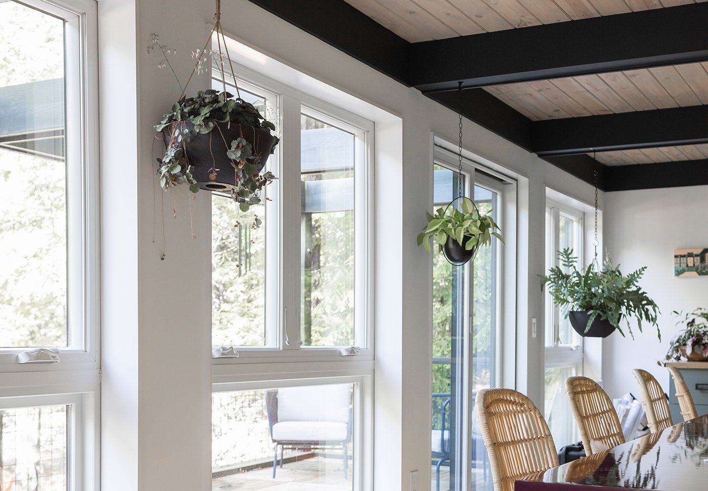 A studio space in a Mid-Century Modern home with a series of floor-to-ceiling window units made of Andersen® 100 Series Casement and Picture Windows with white frames.