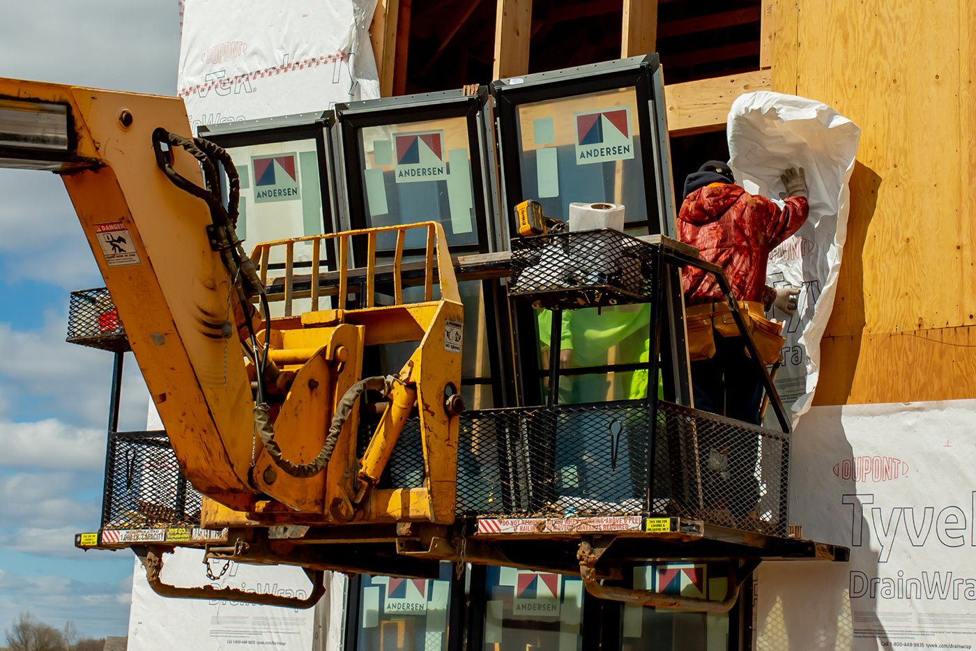 Installers working on putting in windows of a new construction home.