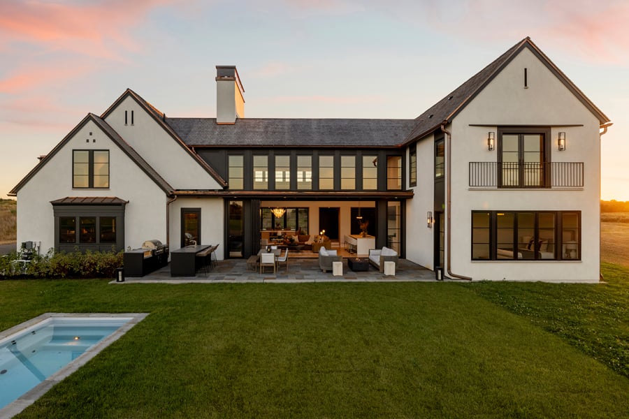 An exterior view of a Modern Tudor with a swimming pool.