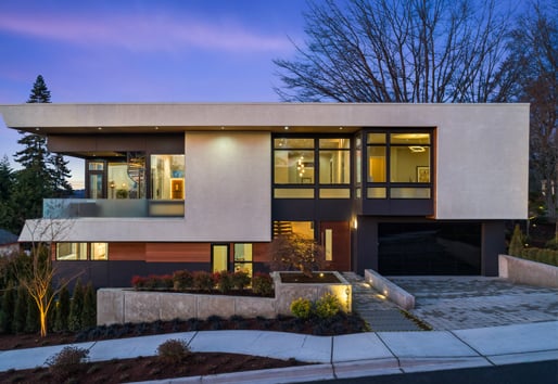The front facade of a Mid-Century Modern home with a flat roof, a balcony on the second floor, and E-Series Casement, Awning, and Picture windows with black exteriors.