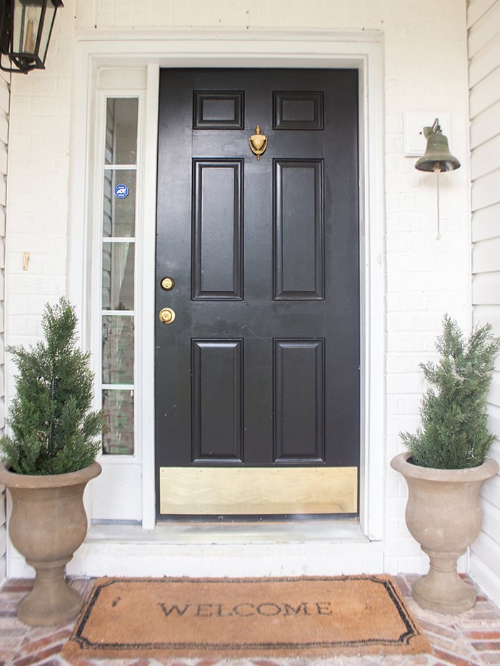 An exterior view of a black front door after a front door replacement on the right and an exterior view of the old door on the left.