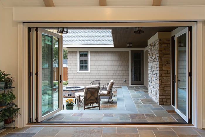 An open Folding Outswing Door leading to an outdoor living area.
