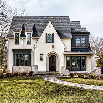 white and black Tudor style home with Andersen black framed windows