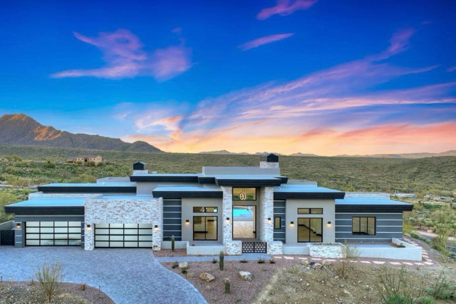 A luxury desert home rendering at sunset with a contemporary design and expansive views created by black Andersen® Aluminum Multi-Slide Doors and 100 Series Gliding and Picture Windows.
