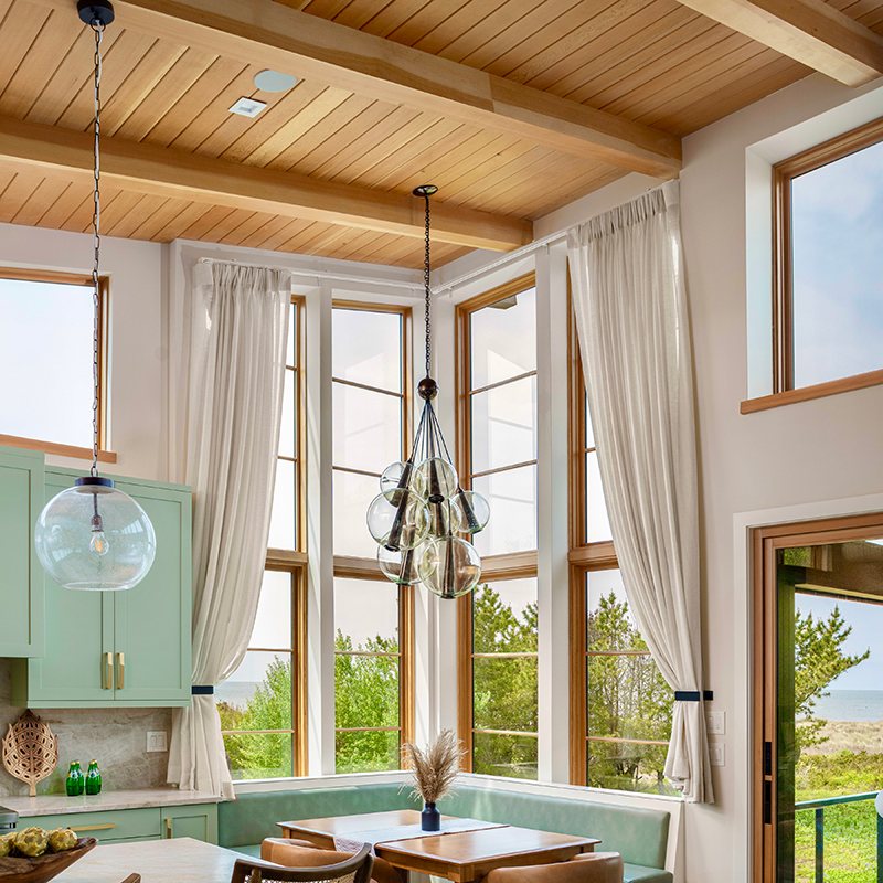 Cottage style kitchen with floor to ceiling windows viewing the ocean