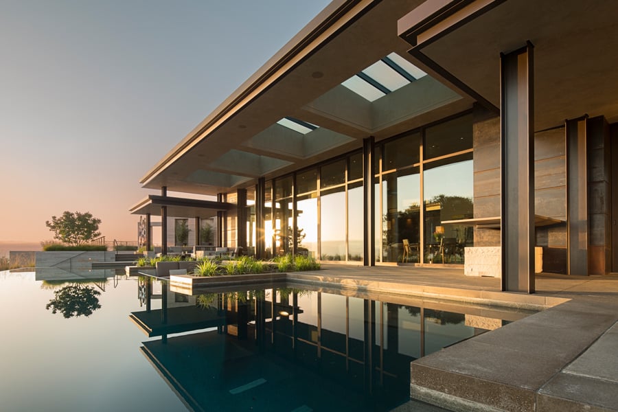Infinity pool with wall of windows and Weiland Aluminum Wood Liftslide doors