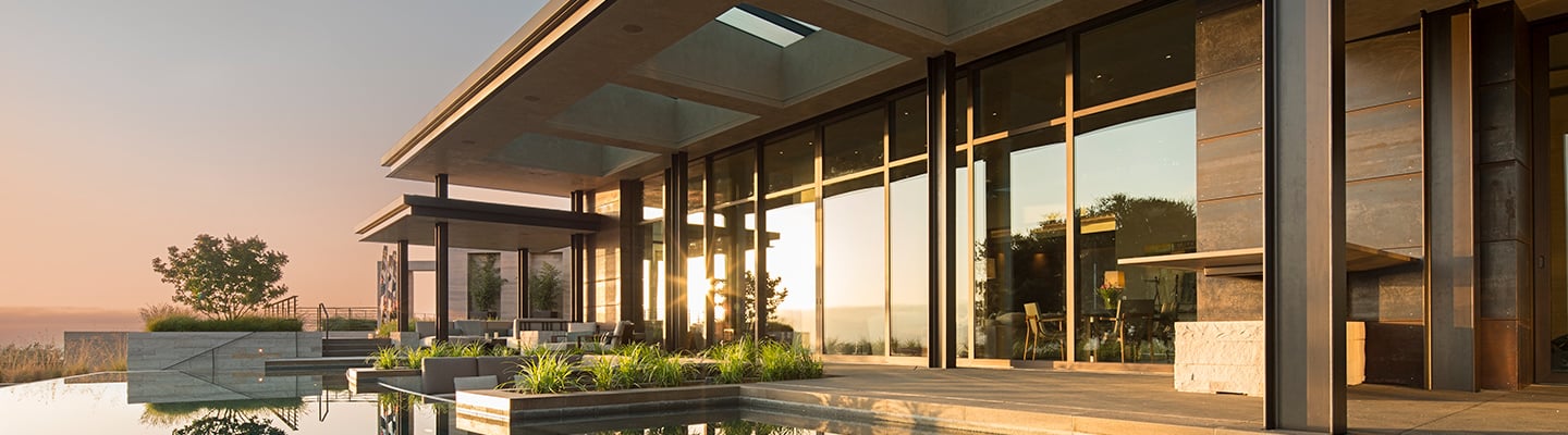 Infinity pool with wall of windows and Weiland Aluminum Wood Liftslide doors