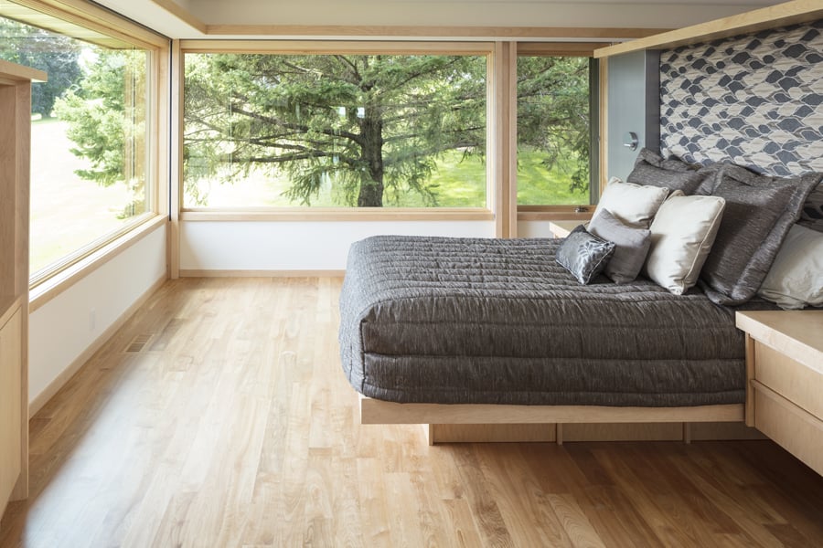 A mid-century bedroom with A-Series corner windows with maple frames. 