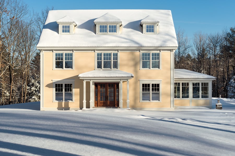 A farmhouse in winter with white 400 Series Double-Hung Windows with modified colonial grilles.