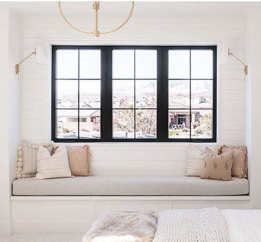 white sitting area looking out black framed windows