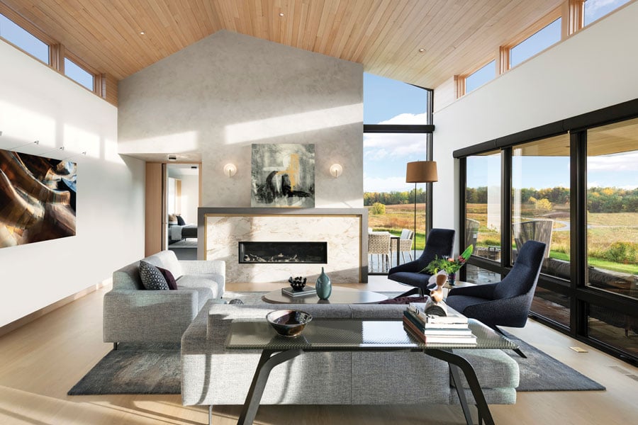 A living room with clerestory windows on both sides and floor-to-ceiling windows facing the backyard.