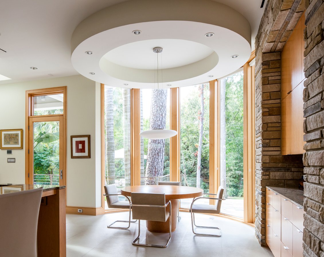 A modern home with a floor-to-ceiling bow window made from Andersen® E-Series Picture Windows.