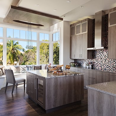 Modern sleek kitchen with breakfast nook surrounded by windows