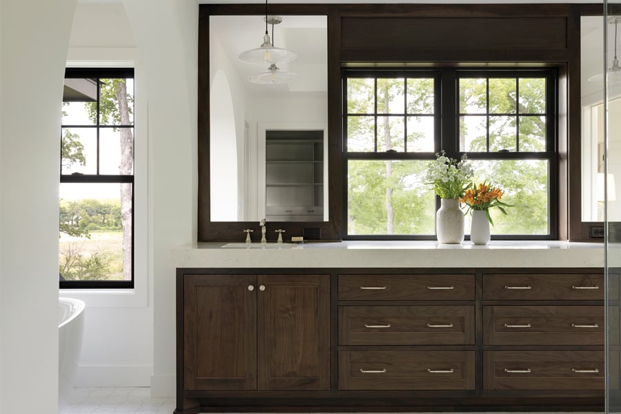 A bathroom with Andersen® 100 Series Single-Hung Windows in between the sinks.