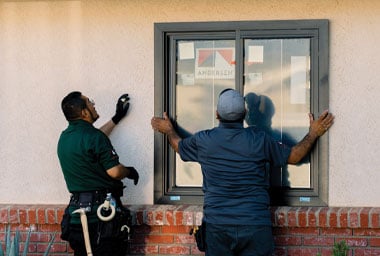two andersen contractors installing window