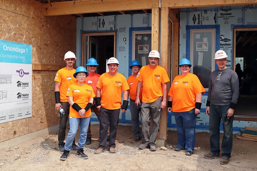 habitat for humanity volunteers in front of a building project