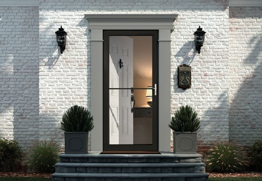 front entrance of white brick home with andersen black framed screen door