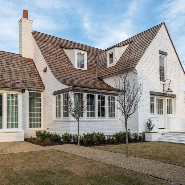 exterior view of Tudor home with Andersen white framed windows