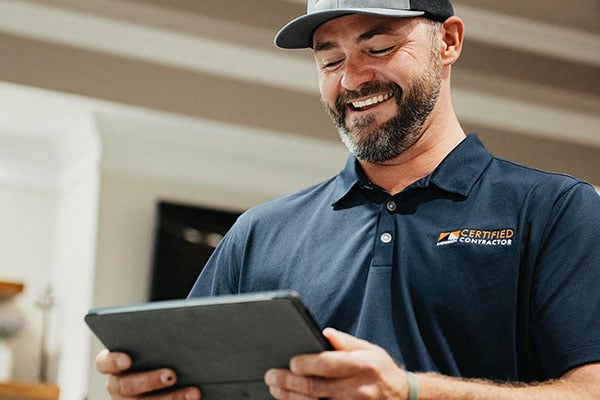 Certified Contractor smiling and using tablet