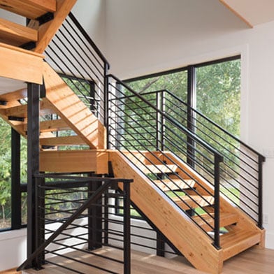 A stair tower with a specialty shaped window configuration that fills the entire wall and floods the stairwell with natural light.