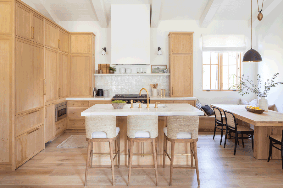 A kitchen with white oak cabinetry, table, and windows.