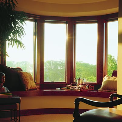 Living room with brown Andersen 400 Series bay windows