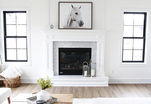 light wood floors in white room with chimney and symmetrical Andersen windows