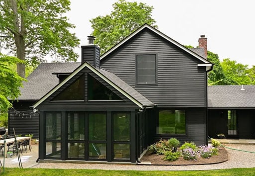 exterior view of dark gray house with screen porch and black framed Andersen windows