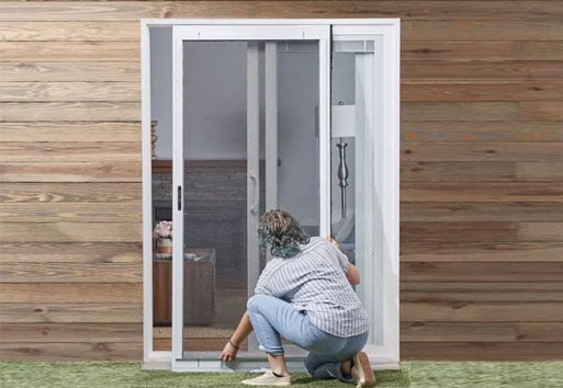 woman on knees installing Andersen screen door