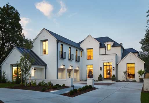 A modern Tudor home makes a high-contrast statement with white painted brick and black-framed Andersen windows.