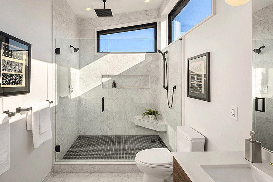 A white bathroom with marble-tiled shower and clerestory windows.