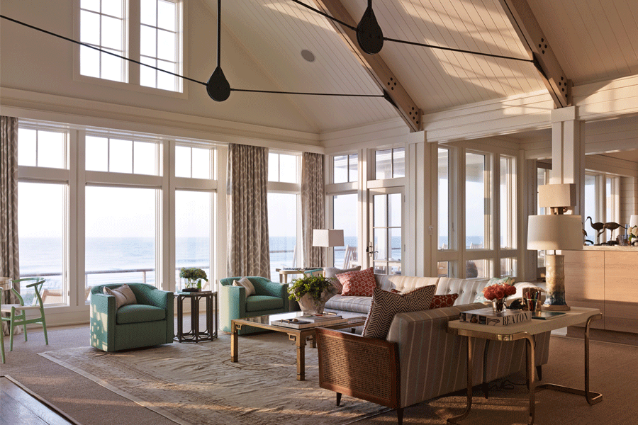 A living room with a wall of coastal windows facing the ocean.