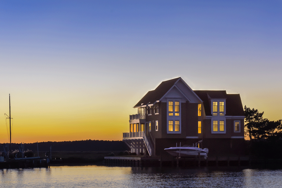 A home with coastal windows glows at sunset.