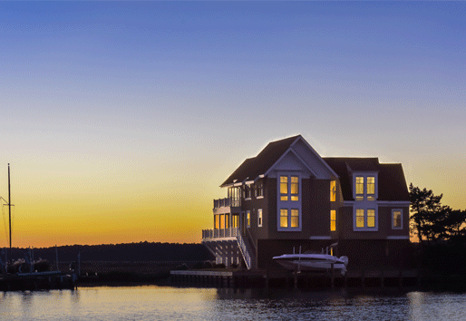 A home with coastal windows glows at sunset.