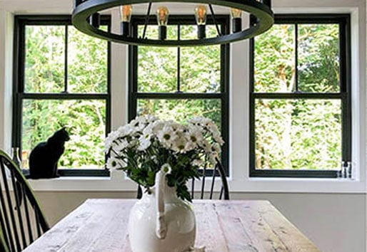 dining room with large farmhouse style light and wood table with vase of flowers