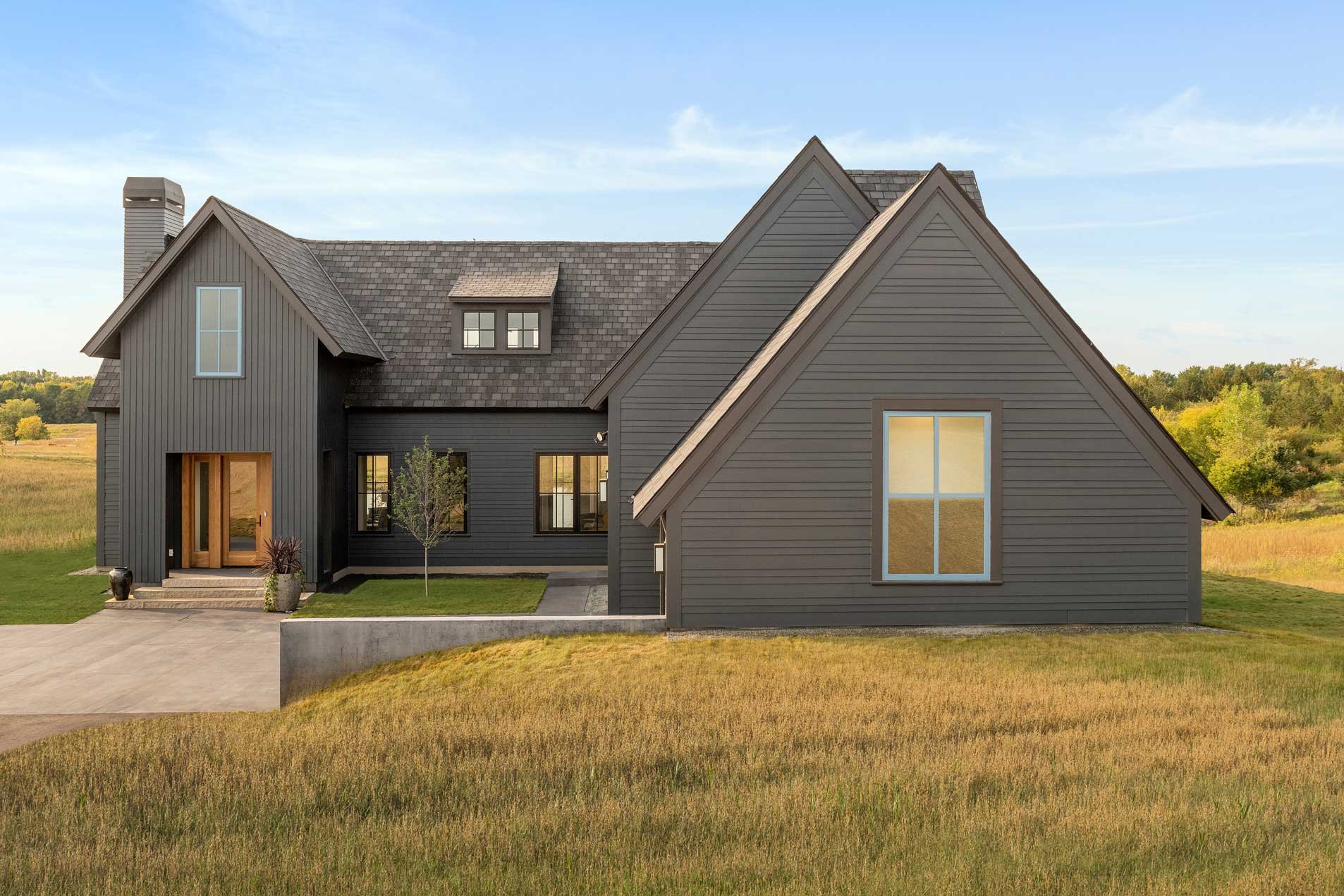 White Oaks Savanna Community, exterior of home in prairie - blue skies, blue windows, black exterior