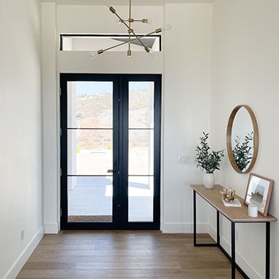 modern front entry with black framed door with grids