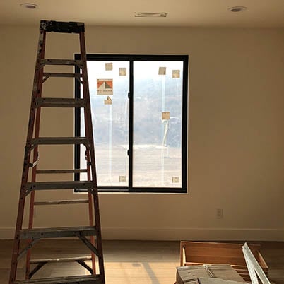 view of ladder in room with black framed window before remodel