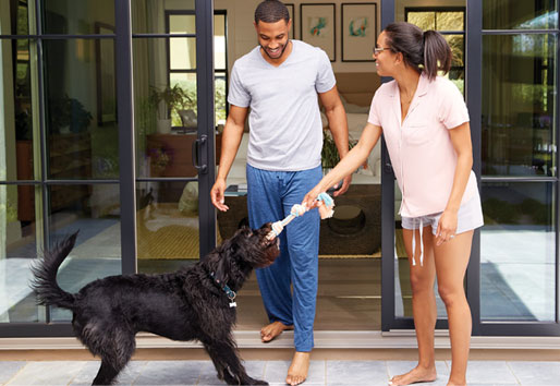 A sliding patio door lets this couple and their dog move seamlessly from the bedroom to playtime on the patio
