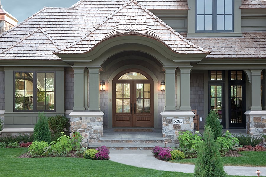 The home above has double front doors and a transom above. To measure a door like this, you would measure the frame, rough opening, jamb depth, and panels. 